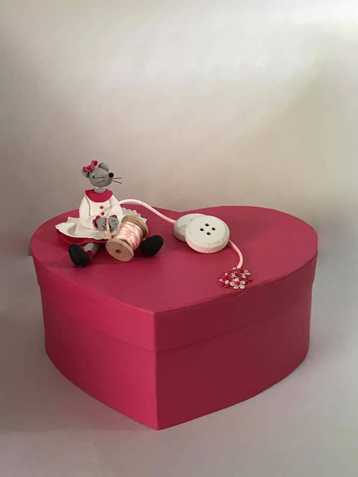 Boite rouge en forme, sur laquelle est assise une petite souris, modeler en porcelaine froide