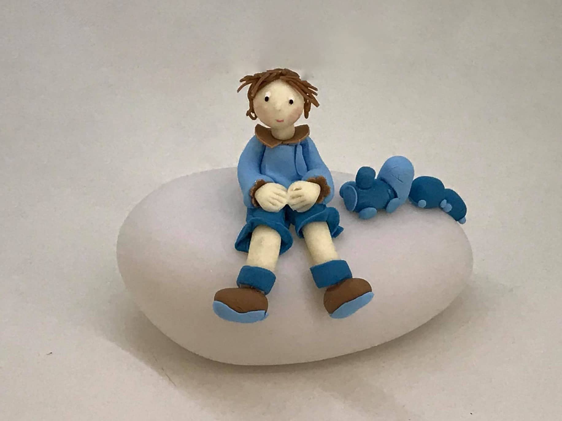 Figurine petit garçon en bleu, sur une boule lumineuse