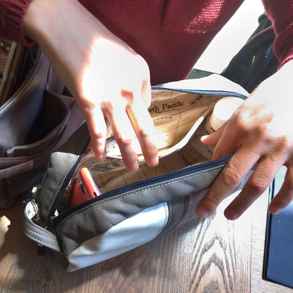Intérieur du petit sac avec un téléphone et une crème solaire