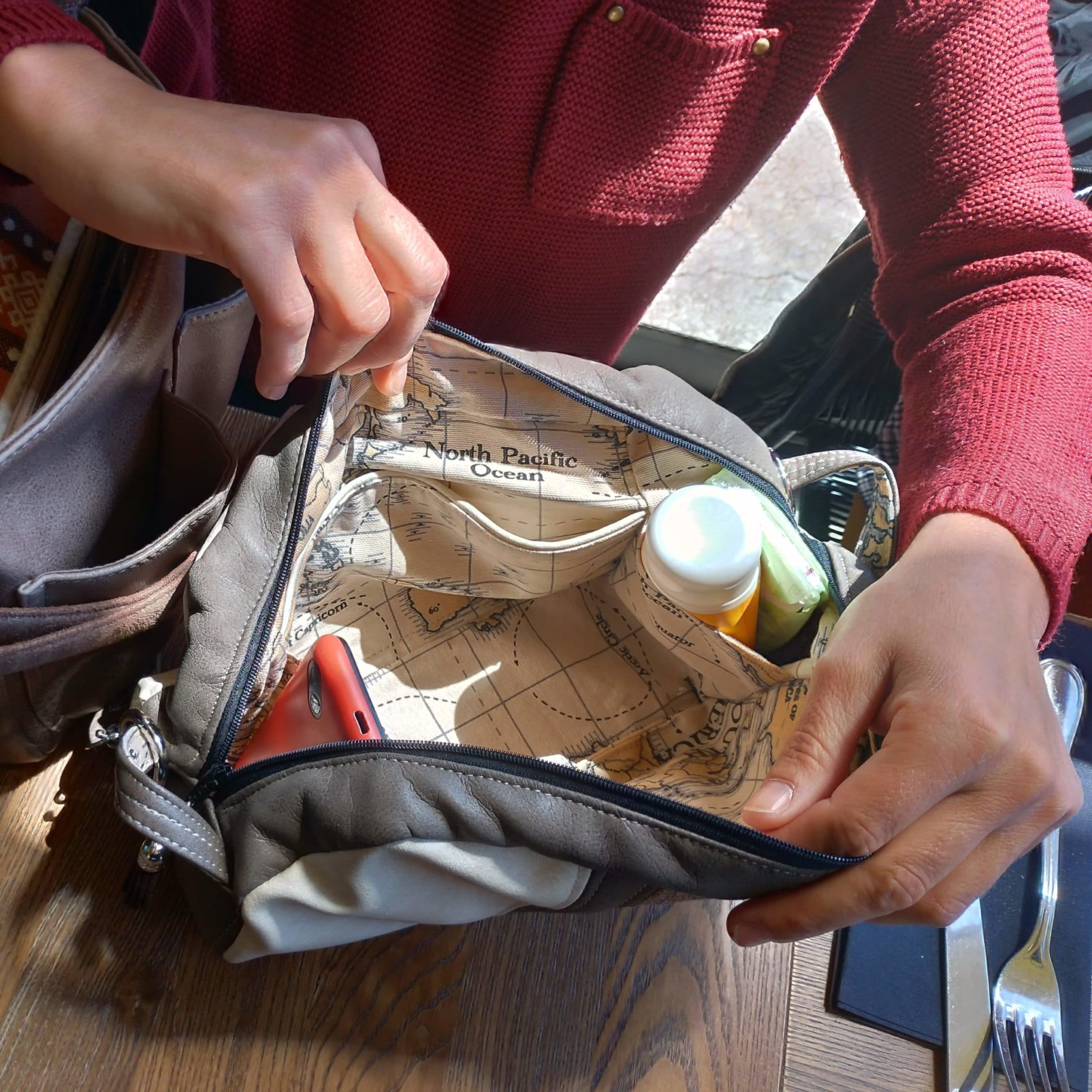 Intérieur du petit sac avec un téléphone et une crème solaire