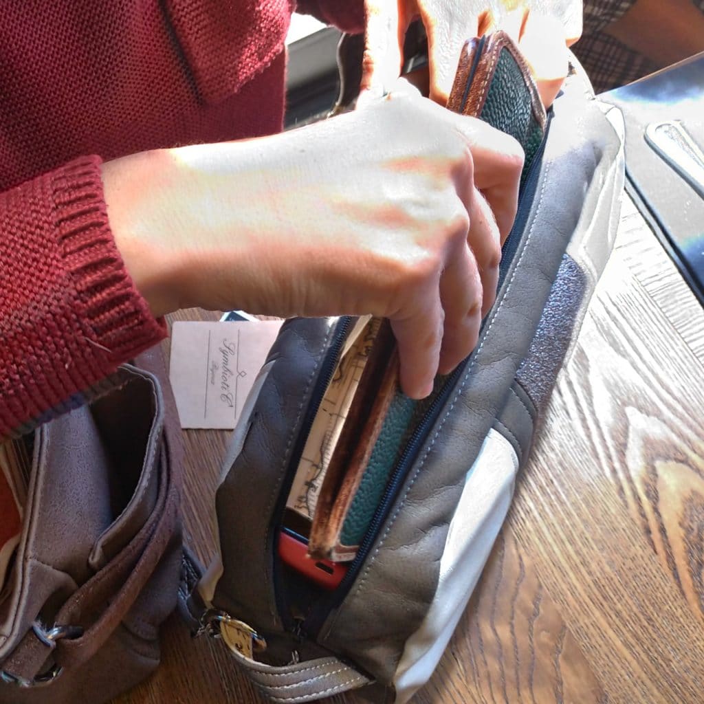 Femme qui met son portefeuille dans son petit sac