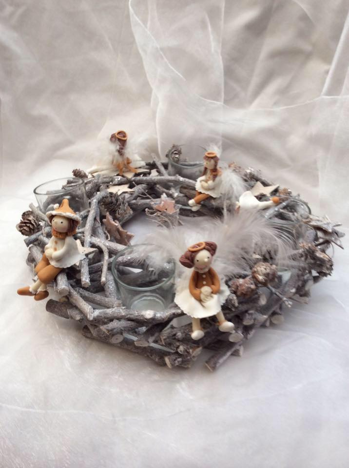 Couronne de bois sculpté avec des figurines en porcelaine froide dans les tons de marron beige.