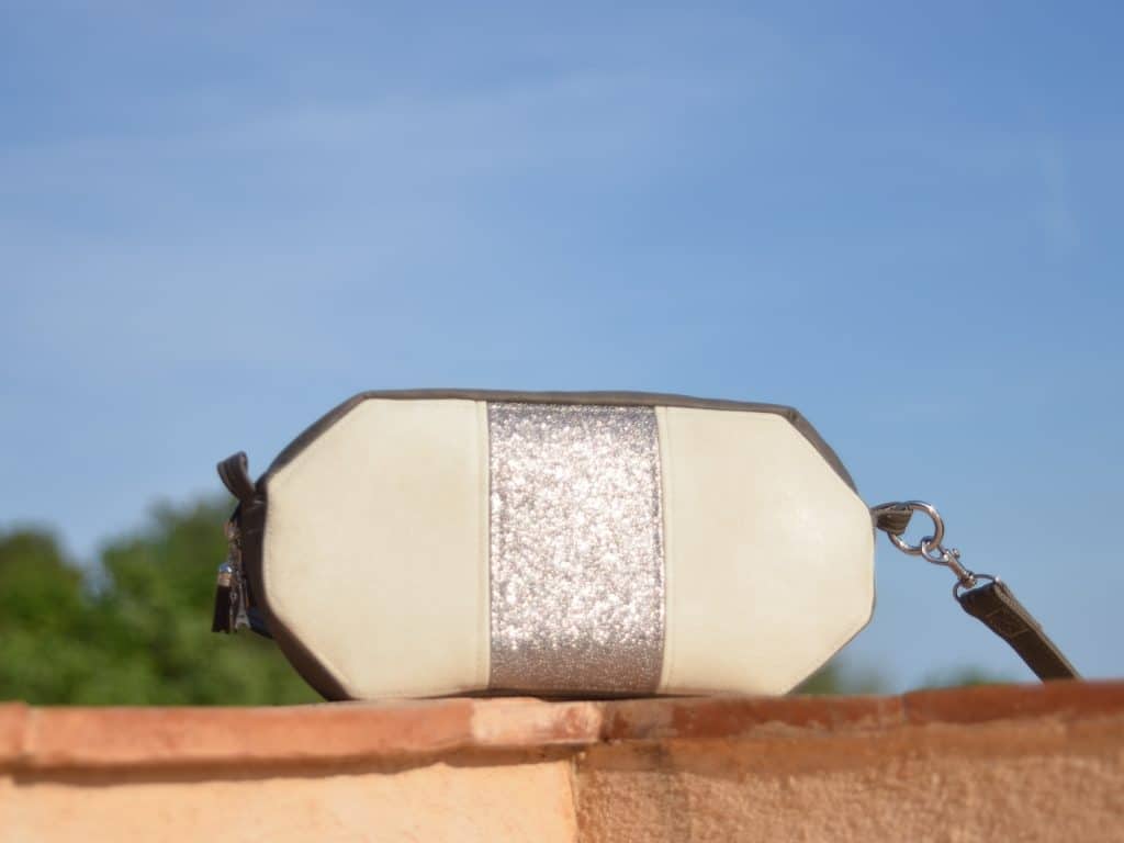 Sac de forme octogonale, blanc et taupe, posé sur le rebord du mur
