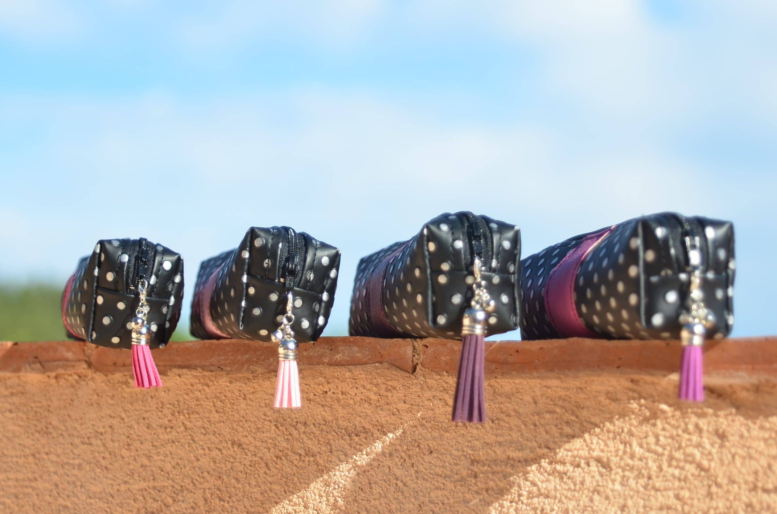 4 trousses à maquillage posées sur un mur.