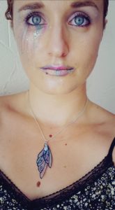 Portrait d'Amélie Debiossat, maquillée avec dans les tons de roses et violets avec des paillettes.