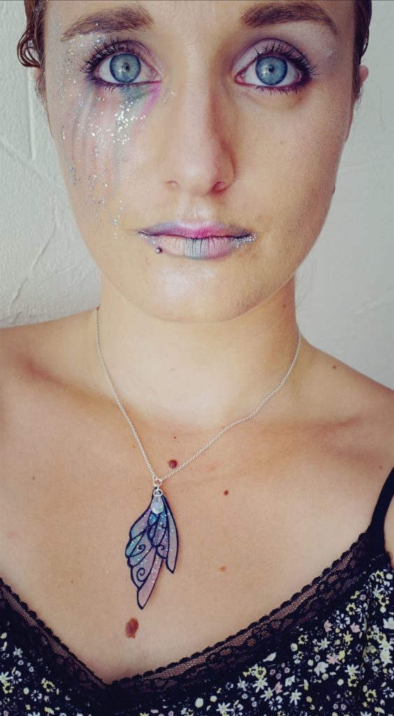 Portrait d'Amélie Debiossat, maquillée avec dans les tons de roses et violets avec des paillettes.