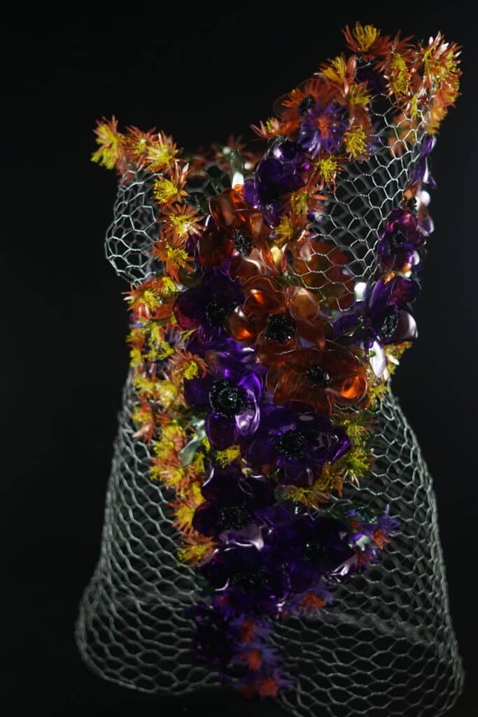 Buste en cage de fer décorée avec de fleurs fabriquées à partir de bouteilles en plastiques.