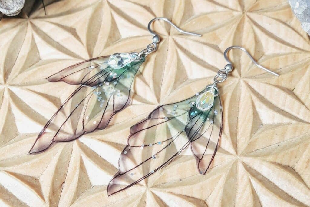 Boucle d'oreille ailes de fée, en résine et sa perle de swarovsky, réalisées par Pebilie
