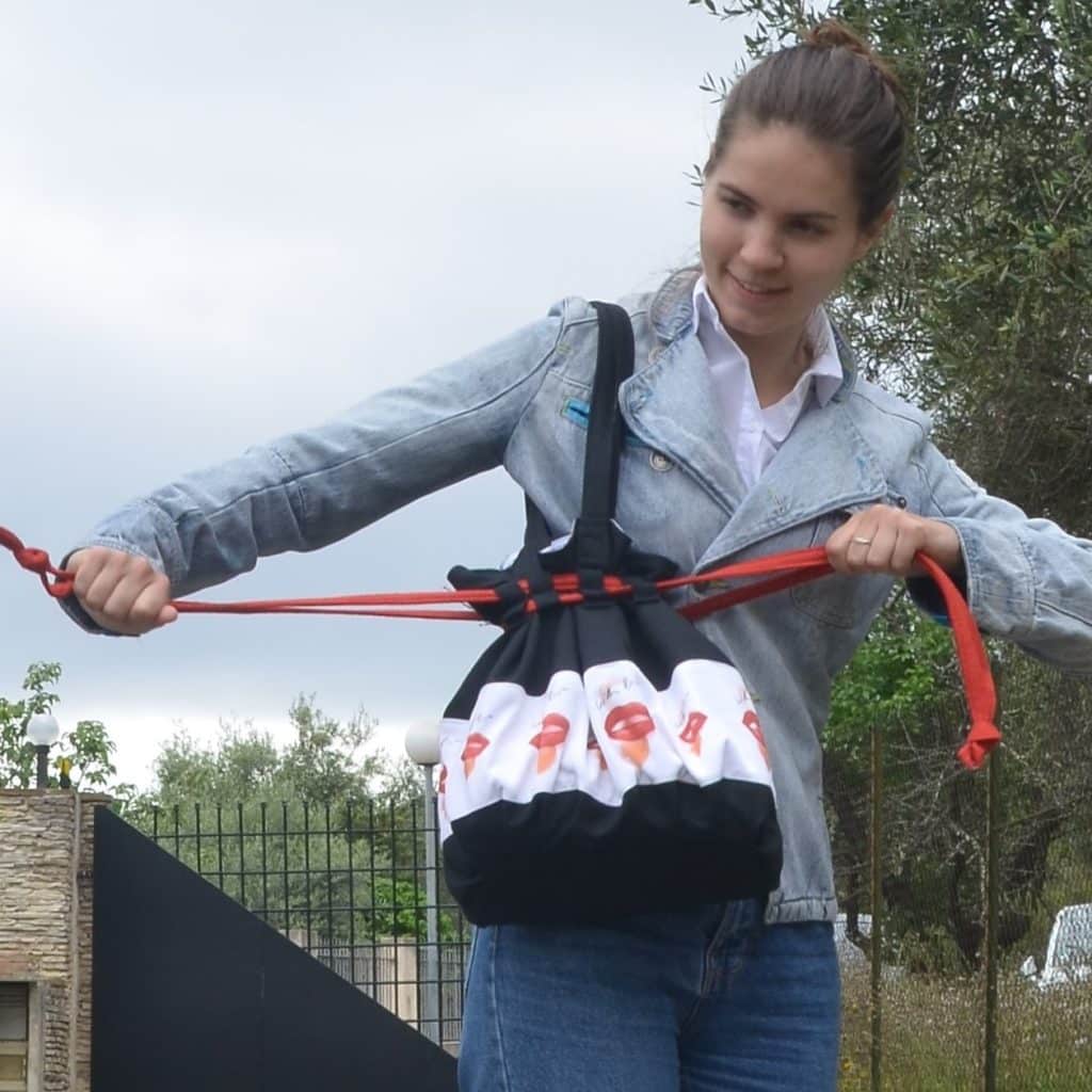 Femme qui ferme énergiquement son sac noir et rouge, signification du rouge