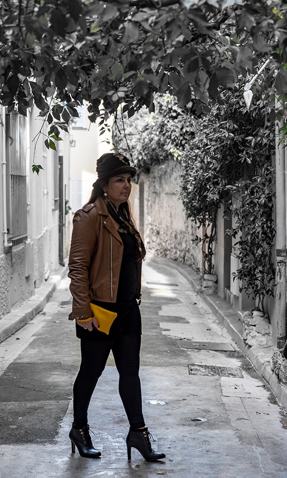 Femme qui flane dans la rue avec une pochette de créaticre, jaune et marron à la main