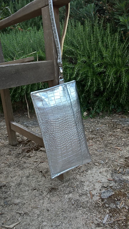 Quel style de pochettes pour ton réveillon ?Pochette réveillon argenté, suspendu au bras d'un banc en bois