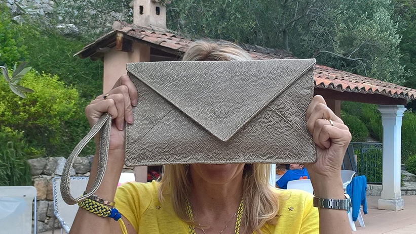 Ce n'est surtout pas comme ça que l'on porte une pochette de réveillon ! Femme au bord d'une piscine qui porte sa pochette réveillon