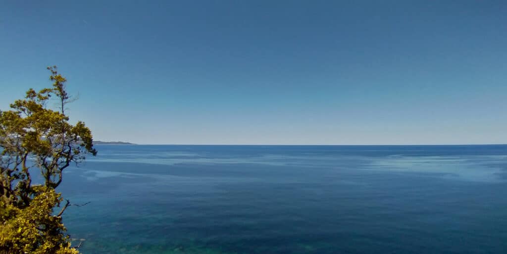 Signification du bleu clair : paisible - Vue sur l'horizon entre ciel et mer méditerranée. Point de vue d'une falaise Corse