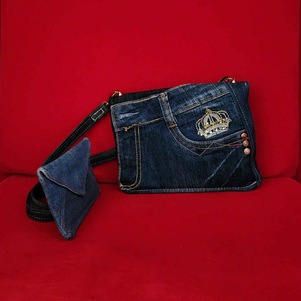 2 Pochettes enveloppes en jean de récupération, posées sur du velours rouge, tout ce qu'il y a de plus élégant pour une femme.